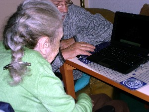 Günter hat den Laptop mitgebracht und schaut mit Mama Fotos an